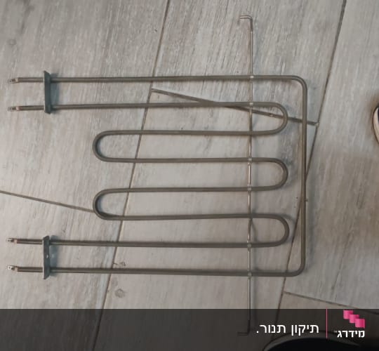 גוף חימום מתכתי על רצפת עץ
